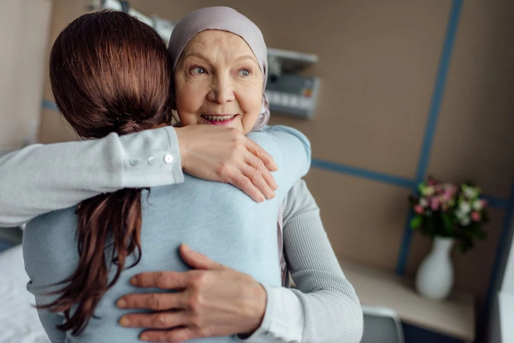 clinician hugging an elderly lady in hospital