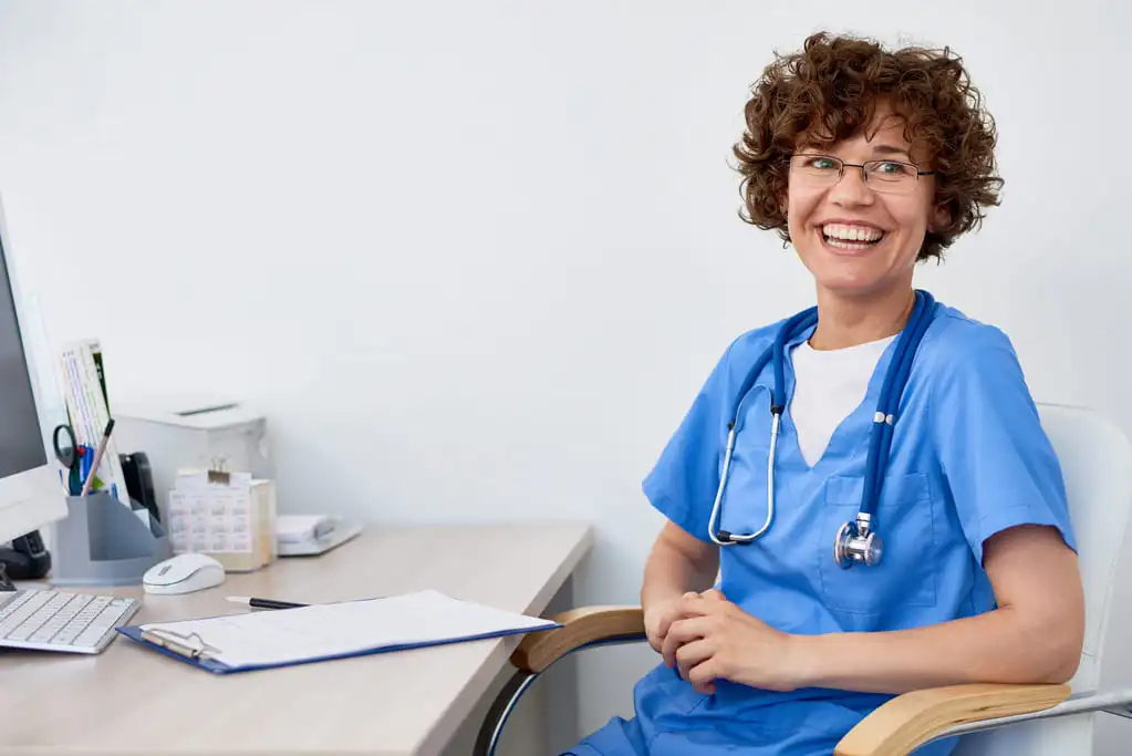 smiling doctor sitting on her desk